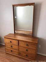 Frontal view of 6 drawer dresser with attached mirror showing wood finish and metal ring pulls.