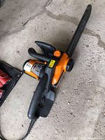 Full view of the WORX WG303.1 electric chainsaw showing the blade with cover, handles, and power cord.