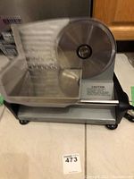 Full view of Waring Pro electric food slicer showing blade, food carriage, and base.