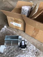 Box containing the fireplace cross flow vents, one vent is visible wrapped in bubble wrap beside the box.