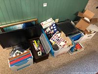Overview of lot showing 27-inch monitor, office supplies, paper cutter, toolboxes, and plastic storage boxes