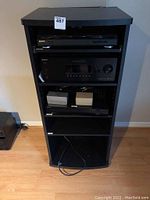 Full view of black pressboard cabinet housing stereo components including turntable, receiver, and DVD system