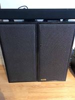 Front view of two Tangent speakers side by side with Amazon Basics soundbar on top