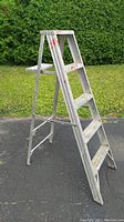 Side view of aluminum four step ladder showing steps and painted marks.