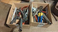 Two boxes containing assorted hand tools: pliers, wrenches, hammers, pry bars, and other tools visible.