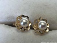 Front view of 10k gold pierced earrings with pearl centers showing scalloped design.