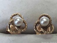 Front view of the earrings showing twisted 10k gold loops and pearl centers.