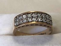 Front/top view showing three rows of round colorless stones across the band