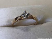 Front view of 10k gold ring showing clear round stone and smooth polished band