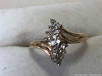 Front angle showing marquise-shaped diamond cluster and wave shoulders