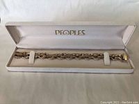Bracelet displayed inside white velvet-lined presentation box with 'PEOPLES' gold logo