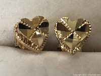 Front view of the pair of heart-shaped earrings showing faceted surface and beaded edge detail.