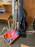 Full view of the lot showing beach cart, umbrellas, sand anchors, toy shovels, towels, pool noodle, walking sticks