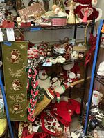 Photo of four shelf unit containing various Christmas decorations including stockings hanging, Santa and snowmen figurines, and candy cane stocking holders.