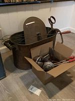 Photo of vintage copper boiler with lid, large whisk, and vintage ice tongs in a cardboard box.