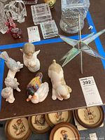 Photo showing Herend porcelain ducks, DAO dog figurine, Lladro angel, Moravian star, and some crystal boxes on a table.