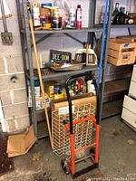 Wide view of the vinyl coated metal rack with assorted supplies and handcart