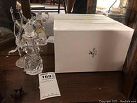 Photo showing two Swarovski crystal figurines alongside the white Swarovski SCS box, highlighting the set contents and packaging.