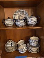Teapot, sugar bowl and large serving plate displayed on shelf