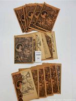 Overview photo showing 18 worn issues of The Crossroads Of Love magazine with illustrated covers and visible wear.