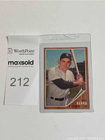 Front side of 1962 Topps #360 Yogi Berra baseball card in protective sleeve with MaxSold lot number tag