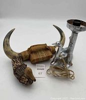 Three animal themed home decor items: ornamental horns, bird lamp, and stick duck figure