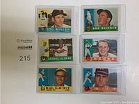 Six 1960 Topps baseball cards arranged in two columns of three each, all in protective sleeves, clearly showing front of cards with player photos and names.