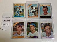 Six vintage Topps baseball cards in plastic sleeves, each card shows a player from 1964 or 1966 with team and position.