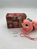 Kitten slinky pull toy in front of original box, showing overall look of toy and box condition