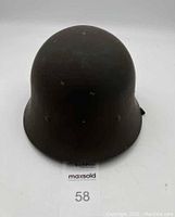 Front view of the olive drab Vietnam War era M1 helmet showing wear and scratches on the surface.