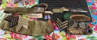 Wide shot of all items showing belt, rank insignia, collar pins, pipe, Dunhill lighter, brushes, glasses, and dog tags.