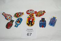 Front and back views of 1960s tin clicker noise makers featuring circus and animal themes.