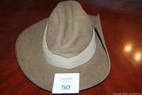 Front angled view of tan Australian military hat with wide brim and light-colored band, size card 50 visible.