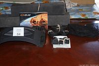 Full set items arranged on a table: foam blocks, plastic brackets, securing straps, mesh bag, and manufacturer instruction booklet.