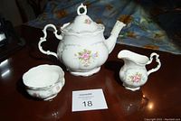 Front-angle view of teapot, creamer, sugar bowl on tabletop