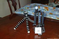 Photo showing bendy leg tripod and gray multi-mount with blue grip adjustable arms on wooden table