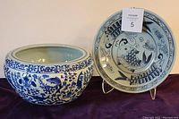 Front view of both blue and white bowls, showing fish designs and overall shape