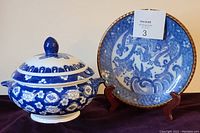 Blue and white lidded porcelain bowl and Japanese transferware plate on stand, displayed together
