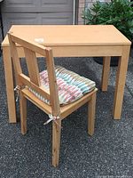 Front and side view showing the chair with patterned cushion and the desk.