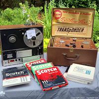 Sony reel-to-reel recorder and Eicor tape recorder in case alongside three unopened Scotch tape boxes and four white boxes of additional tapes