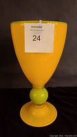 Front view of the yellow art glass vase with apple green trim and base, showing its full height and shape.