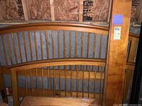Photo showing the headboard and footboard of the wooden bed frame with spindle design in a storage area.