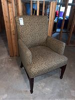 Front-right angle view of the stuffed armchair showing upholstery and wooden legs.