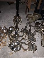 Full view of the chandelier showing six arms with glass or acrylic prisms attached and the central glass column.