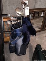 Full view of the golf clubs arranged inside the navy blue Affinity golf bag, showing irons and woods with some head covers.