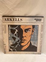 Front cover of Arkells' Morning Report vinyl showing a stylized male face partly disintegrating.