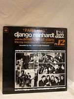 Front cover of vinyl record album titled 'Paris 1945' by Django Reinhardt, showing black cover with white and orange text and multiple black and white musician photos.