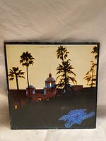 Front cover of the Eagles "Hotel California" vinyl record album showing the iconic building with palm trees at dusk.