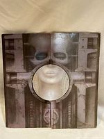 Front of gatefold cover showing biomechanical face with a circular cutout