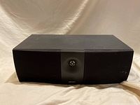 Front view of Energy center channel speaker with black fabric grille covering drivers and tweeter.